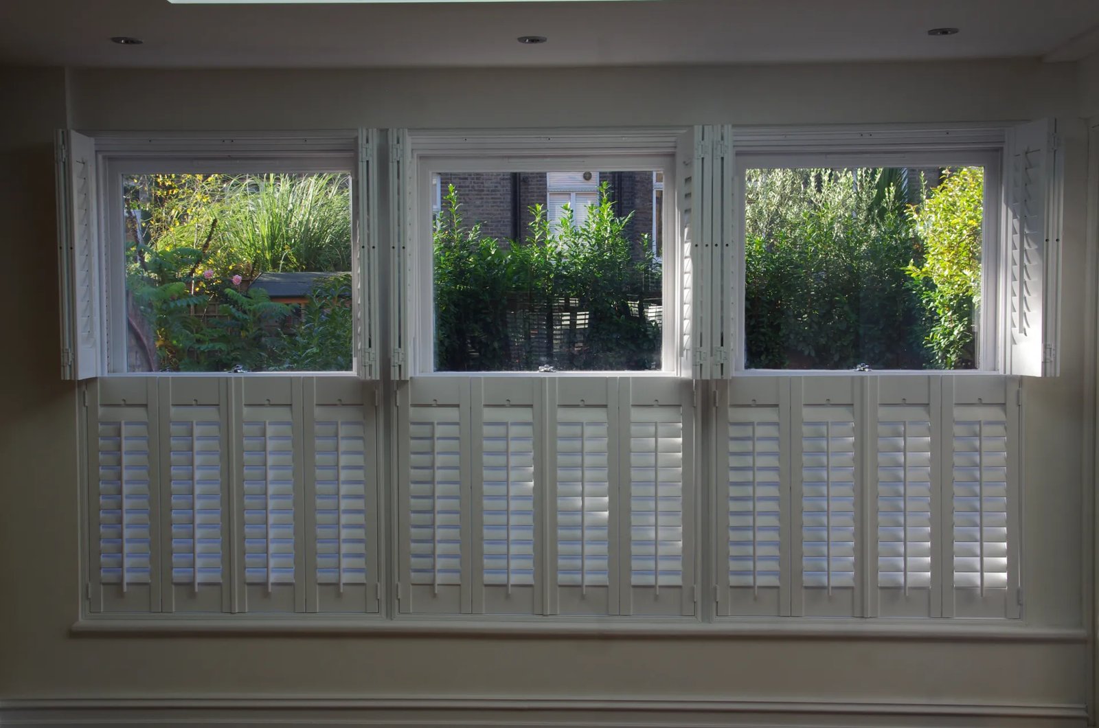 Café-style shutters covering only the lower half of Suffolk windows for street-level privacy